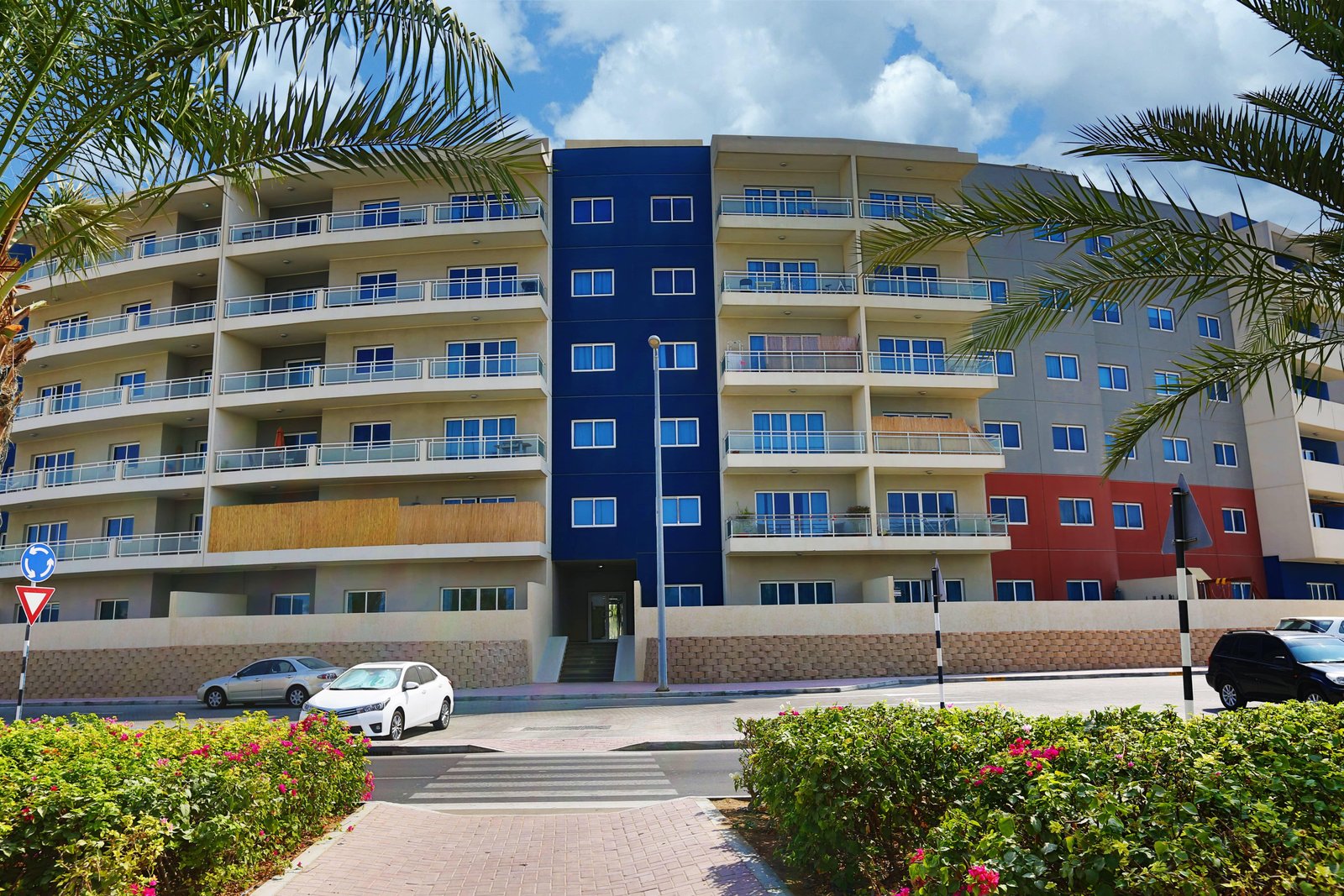 Contemporary exterior architecture of Al Reef Downtown showcasing elegant apartment buildings and vibrant community living.